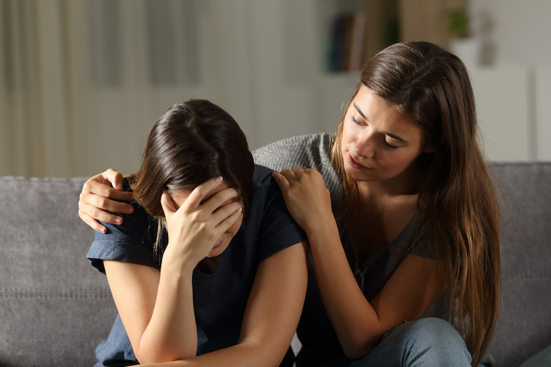 Woman with hands crossed over chest in peace and relief.